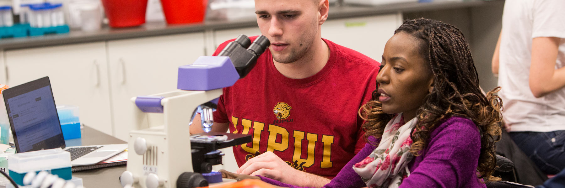 Students use a microscope.